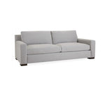 A gray sofa with two cushions and tapered wooden legs