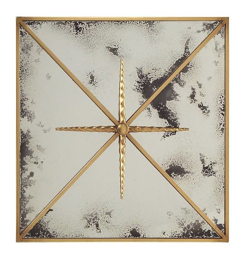 A square mirror with a decorative starburst design in the center, made of small mirrored pieces. The frame is a thin, polished metal.