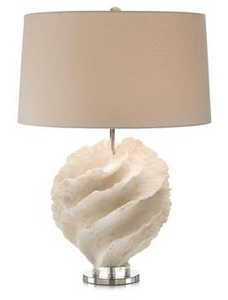 A desk lamp with a white marble base and a beige fabric shade. The shade has a slightly tapered shape and is trimmed with gold banding. The lamp is turned on, casting a warm glow.